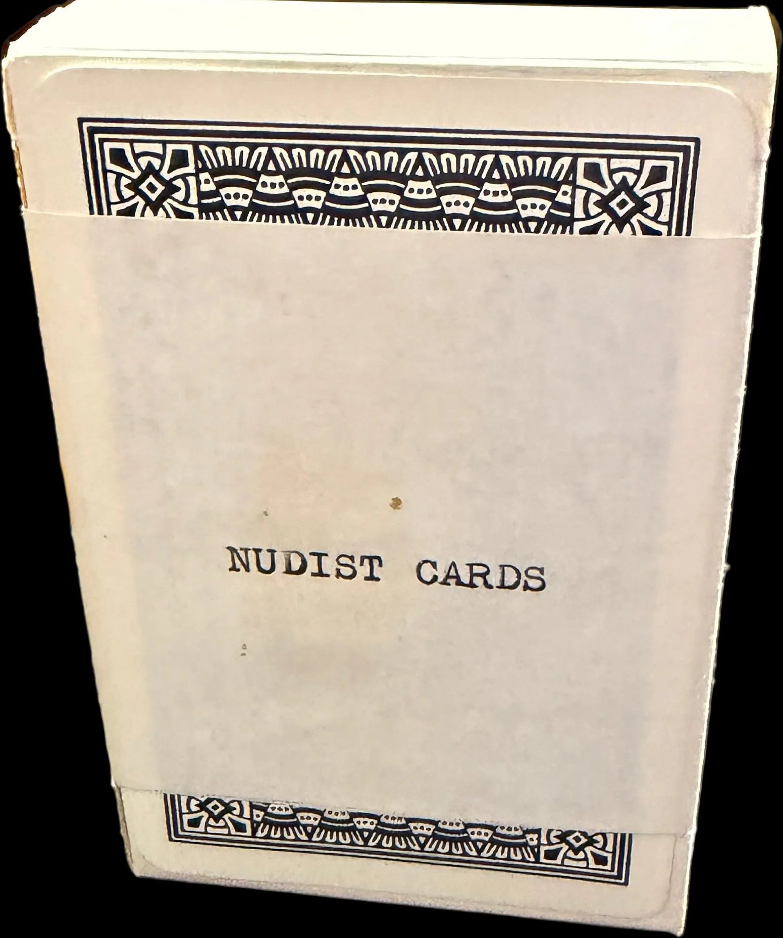 Book titled 'Nudist Caribs' on a wooden surface with a map in the background