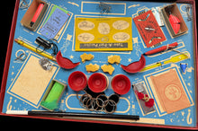 Collection of vintage tools and items on a blue tray with a wooden surface underneath.