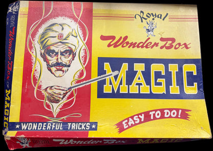 Vintage 'Royal Wonder Box Magic' box with colorful design on a wooden surface.