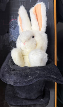 Plush toy rabbit with a black hat on a table