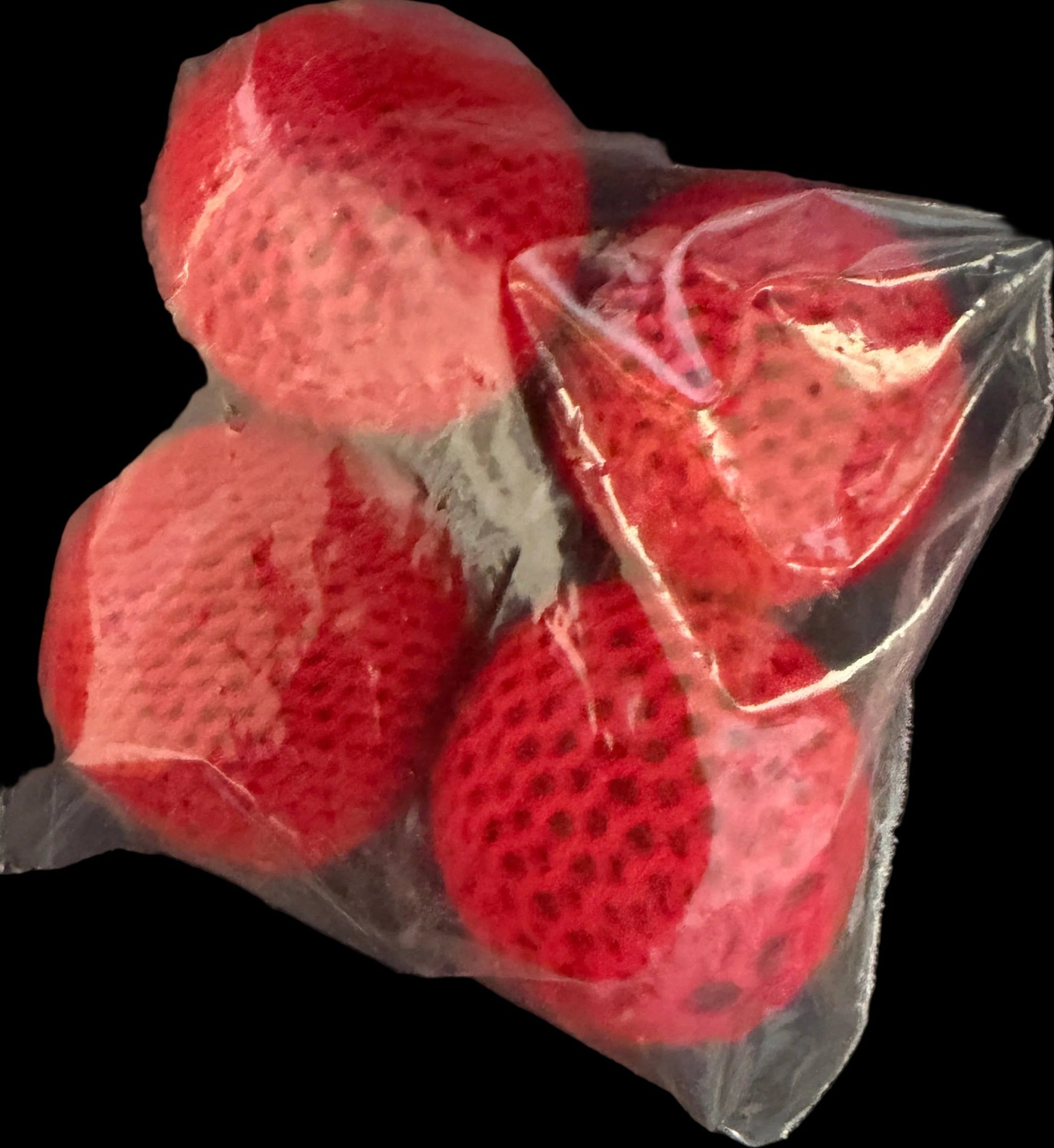 Red silicone pads in a clear plastic bag on a black surface