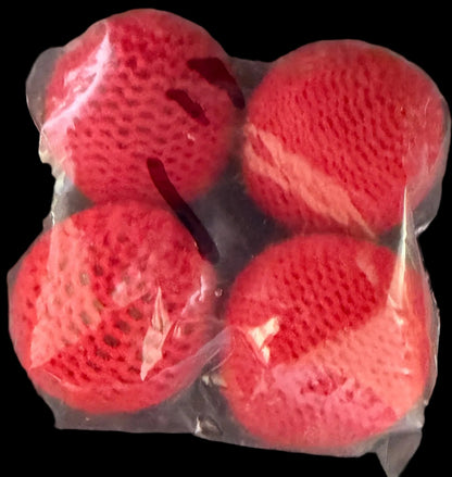 Three red textured balls in a clear plastic bag on a dark surface with text.