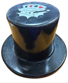 Black cylindrical container with a lid featuring card suits on a wooden surface.