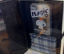 Open book with a plaid fabric cover on a desk next to a computer screen and keyboard.