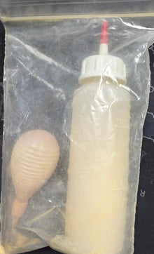 White bottle with red cap inside a clear plastic bag on a dark textured surface