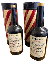 Two wine bottles stacked on a wooden surface with a barbershop pole in the background.