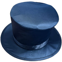 Black top hat on a wooden surface with various items in the background