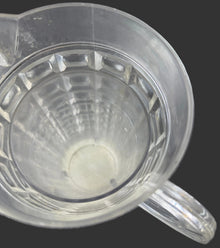 Clear plastic component with a circular opening on a dark background