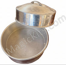 Silver metal bowl and lid on a wooden surface