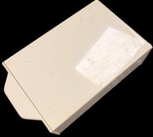 Small rectangular object on a textured surface with text