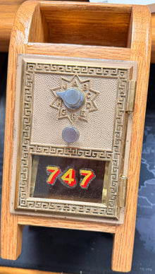 Decorative metal box with '747' on a wooden stand in front of a keyboard