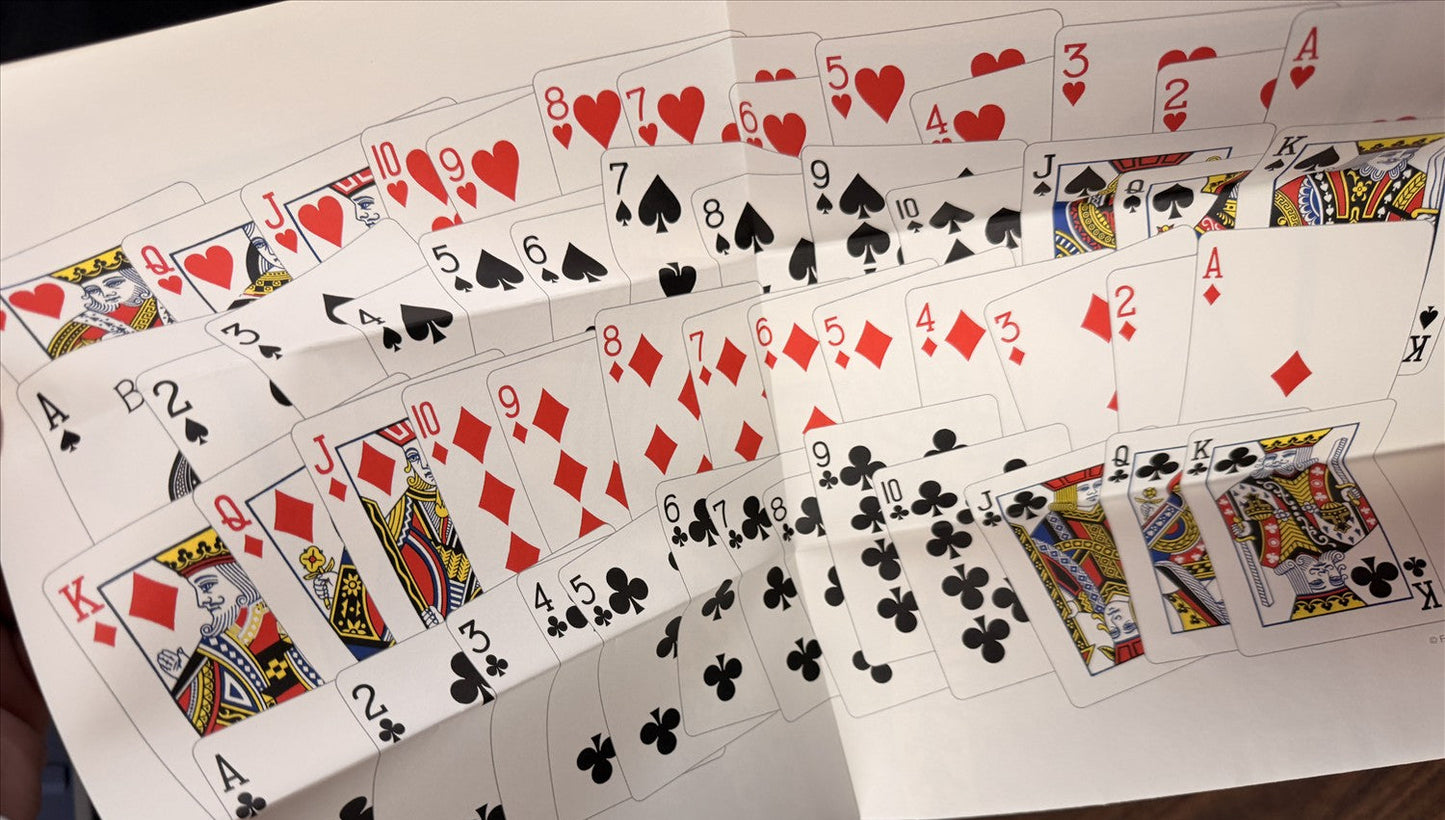 Playing cards spread out on a white surface