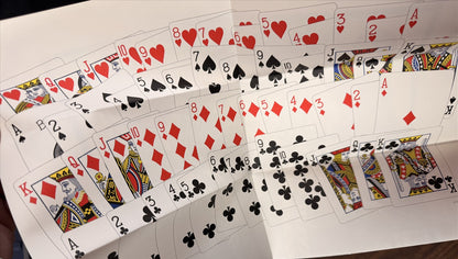Playing cards spread out on a white surface