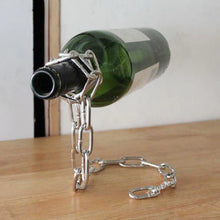 Metal bottle holder with chain holding a wine bottle on a wooden surface.