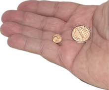 Two gold coins held in a hand against a white background