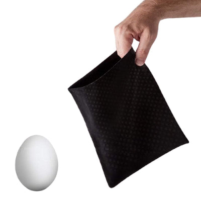 Black egg holder with a hand holding it, next to a white egg on a white background