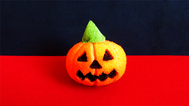 Small Halloween pumpkin with a green top on a red and black background