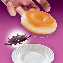 Donut-shaped cookie with a cockroach and a paper plate on a purple background