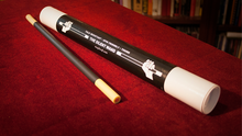 Two black and white sticks on a red surface with a cylindrical black and white tube labeled 'The Silent Hand Tour' in the background.