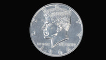 Silver coin with a profile of a person and 'In God We Trust' text on a black background