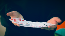Hands holding a deck of cards against a dark background