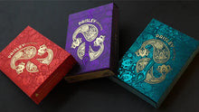 Three colorful card decks with Paisley branding on a dark background