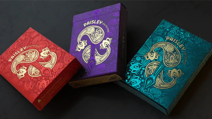 Three colorful card decks with Paisley branding on a dark background