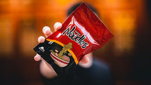 Person holding a red and black Nando's branded food package against a blurred background