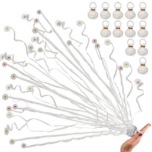 Set of white string lights with decorative ends held by a hand against a white background