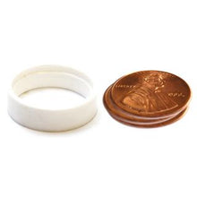 White ring next to a penny on a white background