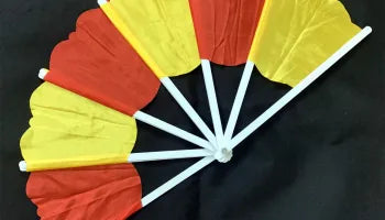 Red and yellow paper fan on a black background