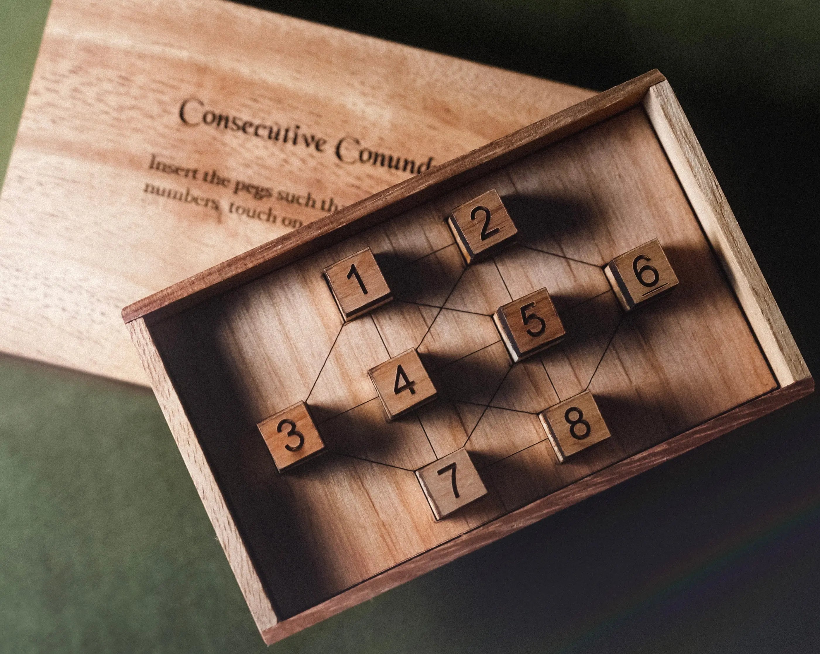 Wooden puzzle with numbered blocks inside a wooden box