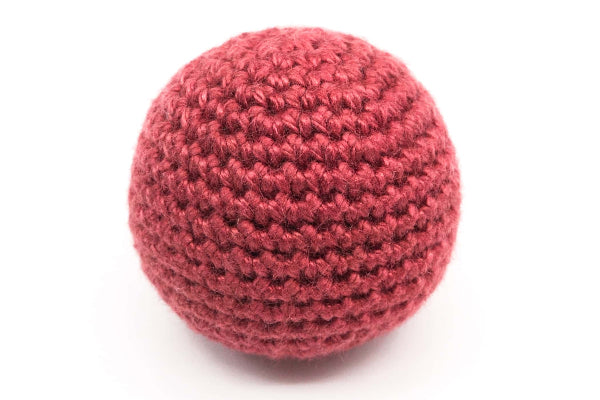 Red crocheted ball on a white background