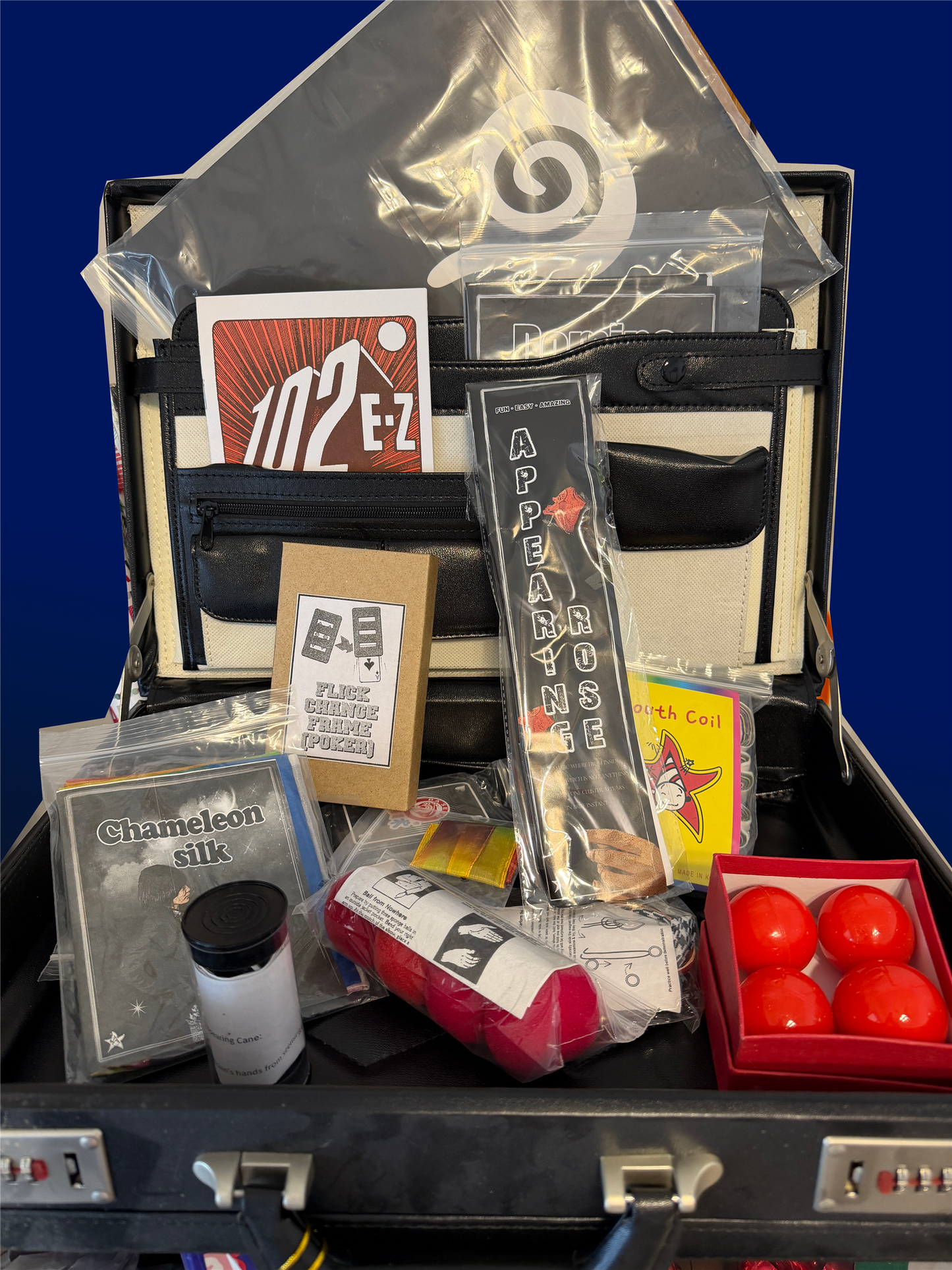 Collection of items including a suitcase, bags, and small containers on a blue background