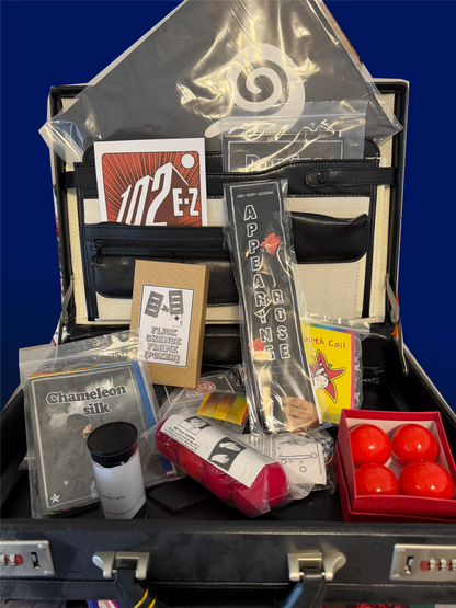 Collection of items including a suitcase, bags, and small containers on a blue background