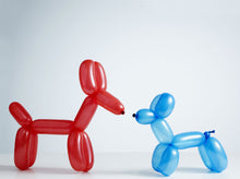 Red and blue balloon dogs facing each other on a white background