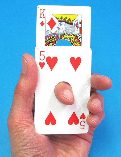 Hand holding a deck of cards with King of Diamonds and 5 of Hearts on a blue background