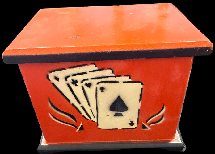 Red box with playing card design on a black surface