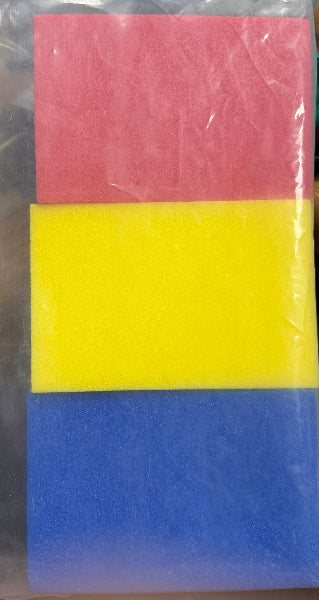 Colorful foam blocks in red, yellow, and blue on a clear plastic sheet.