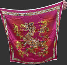 Person holding a pink scarf with gold dragon design in an indoor setting