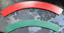 Two curved pieces of red and green material on a world map background