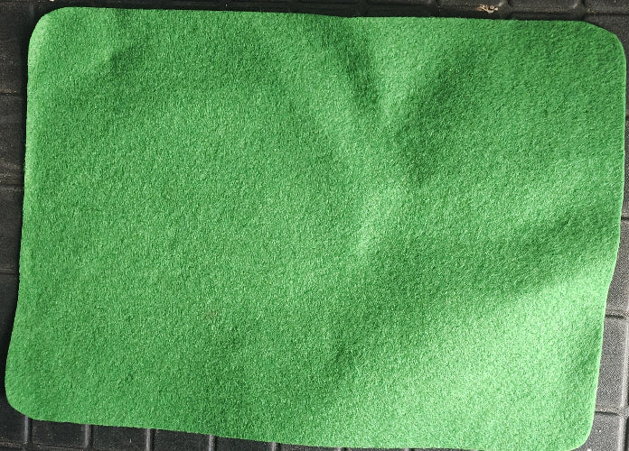 Green felt sheet on a black surface