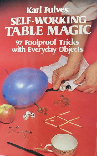 Book cover of 'Self-Working Table Magic' by Karl Fulves with props on a red background