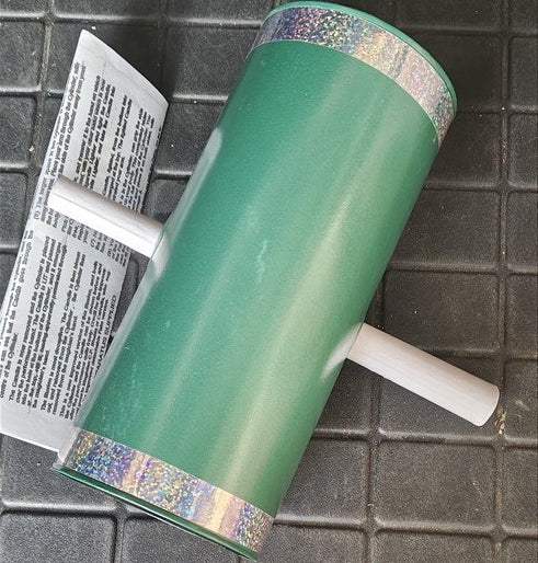 Green roller with a white handle on a tiled floor