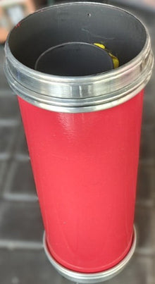 Red cylindrical object with metal rim on a dark background