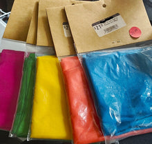 Colorful fabrics in clear bags with cardboard boxes in the background