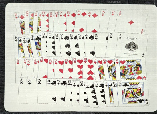 Standard deck of playing cards laid out face up on a flat surface.