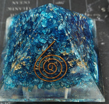 Blue crystal pyramid with a copper spiral on a dark background