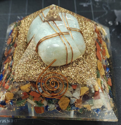 Decorative crystal with gold wire, stone, and colorful mosaic on a dark background