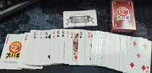 Playing cards with red and black designs on a dark surface